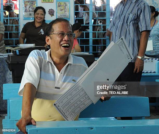 Liberal party presidential candidate Benigno Aquino smiles after casting his vote at a polling center in the village of Central, inside Hacienda...