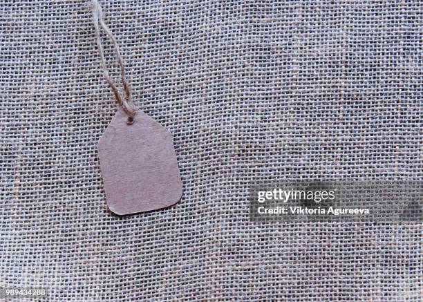 burlap textured surface with a price tag - wildlife tracking tag stock pictures, royalty-free photos & images