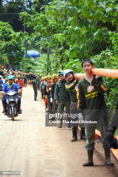 Rescue workers carry heavy water pumping equipments into Tham Luang Nang Non cave on July 1, 2018 in Chiang Rai, Thailand. Rescuers in northern...