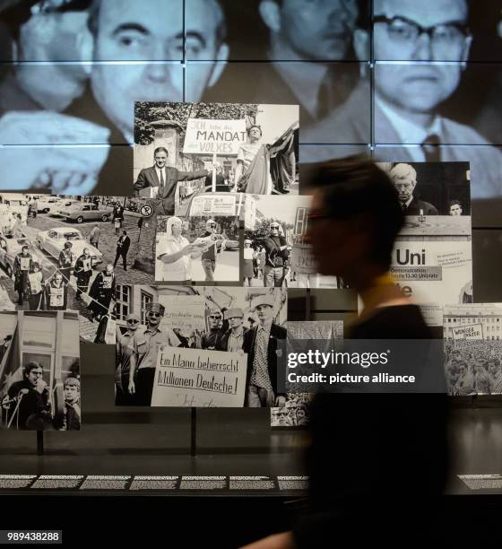 Woman passes by a series of films and pictures in the special exhibit 'Because times change' embedding the time of the 1960s. The exhibition can bee...