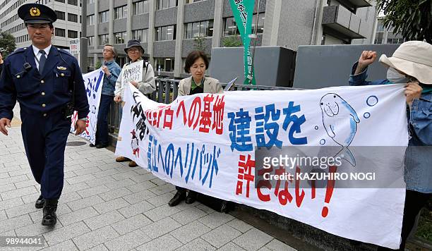 Protesters stage a demonstration with a banner demanding "We do not allow base construction on Henoko" refering to a controversial US airbase in...