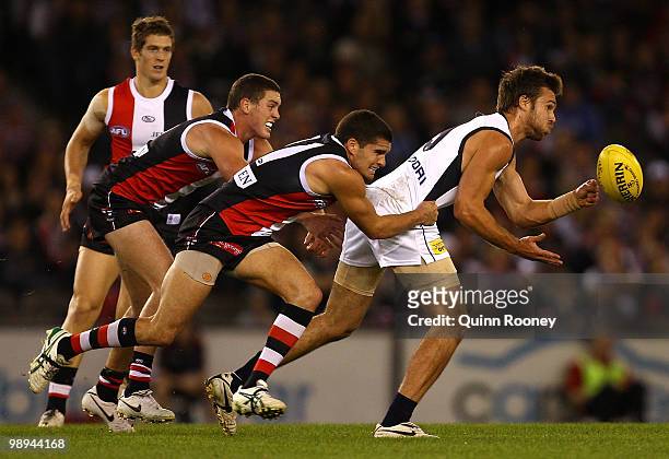 Chris Johnson of the Blues handballs whilst being tackled by Leigh Montagna of the Saints during the round seven AFL match between the St Kilda...