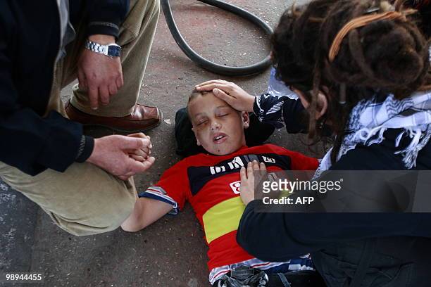 An injured Palestinian youth lies on the ground following clashes between Palestinian demonstrators and Israeli forces on February 5, 2010 after a...