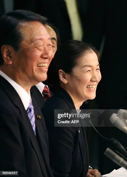 Japanese Judo player Ryoko Tani smiles as she holds a news conference next to Ichiro Ozawa , a political kingmaker and the secretary general of the...