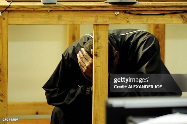 One of the two men accused of the murder of South African white supremacist Eugene Terre'Blanche hides his face in Ventersdorp court on May 10, 2010....