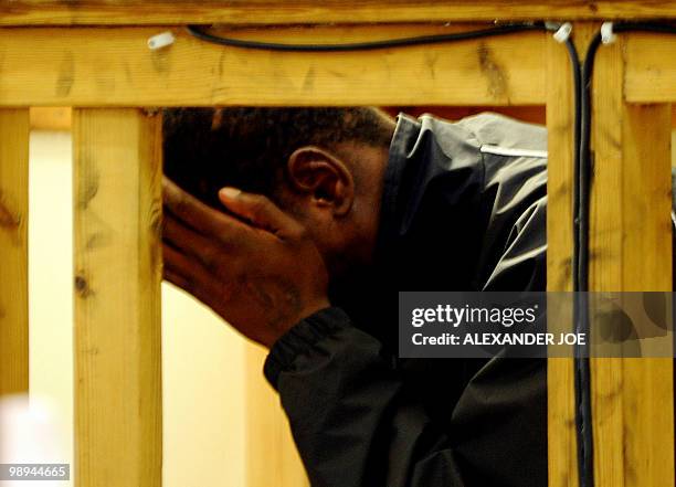 One of the two men accused of the murder of South African white supremacist Eugene Terre'Blanche hides his face in Ventersdorp court on May 10, 2010....