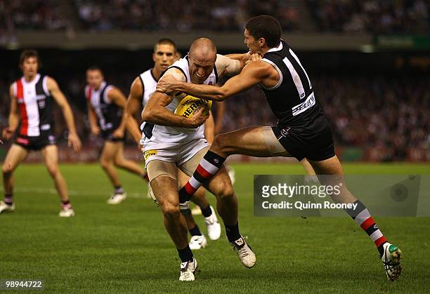 Chris Judd of the Blues fends off a tackl by Leigh Montagna of the Saints during the round seven AFL match between the St Kilda Saints and the...