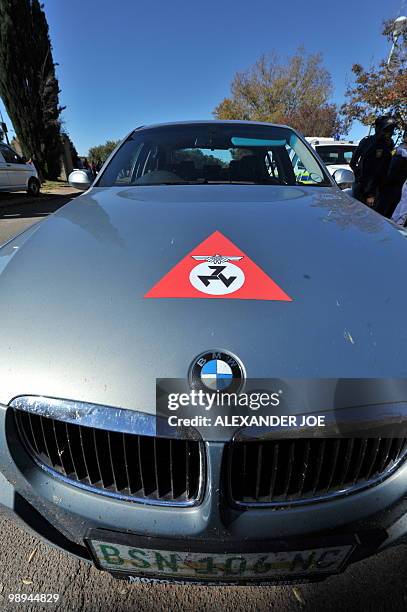 South African police stand guard as a car bearing the emblem of the Afrikaner Resistance Movement founded by Eugene Terre'Blanche is parked during...