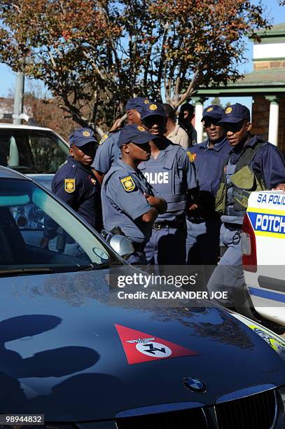 South African police stand guard as a car bearing the emblem of the Afrikaner Resistance Movement founded by Eugene Terre'Blanche is parked during...