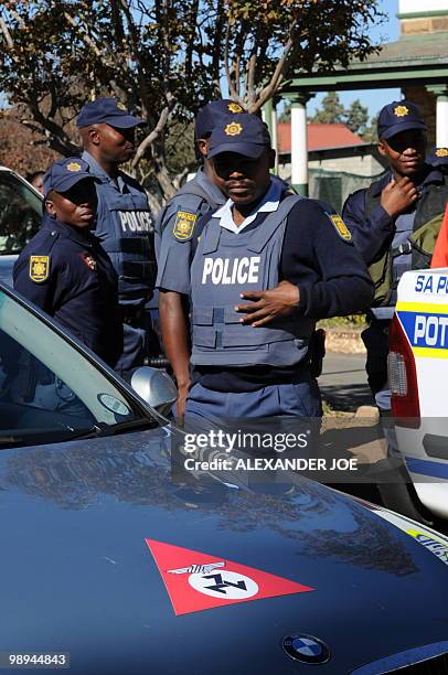 South African police stand guard as a car bearing the emblem of the Afrikaner Resistance Movement founded by Eugene Terre'Blanche is parked during...