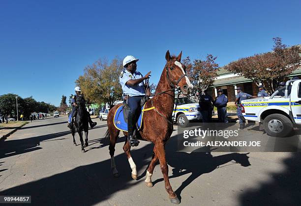 South African police patrol on horseback during the trial of the two men accused of the murder of South African white supremacist Eugene...