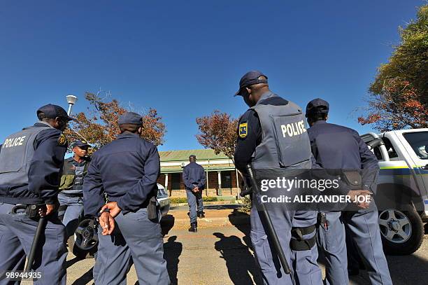 South African police patrol stand guard on the street during the trial of the two men accused of the murder of South African white supremacist Eugene...