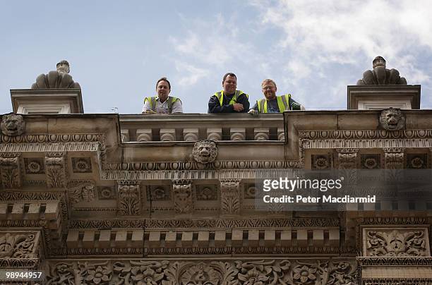 Workmen watch from the roof of The Cabinet Office as Liberal Democrats and Conservative Party negotiators leave after holding talks on May 10, 2010...