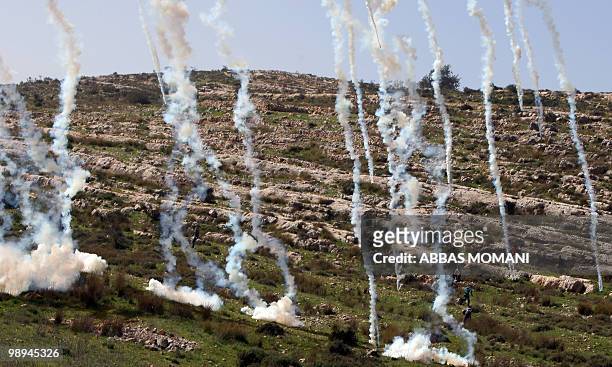 Israeli soldiers fire tear gas to disperse Palestinian protesters during the weekly demonstration against Israeli settlement expansion, in the West...