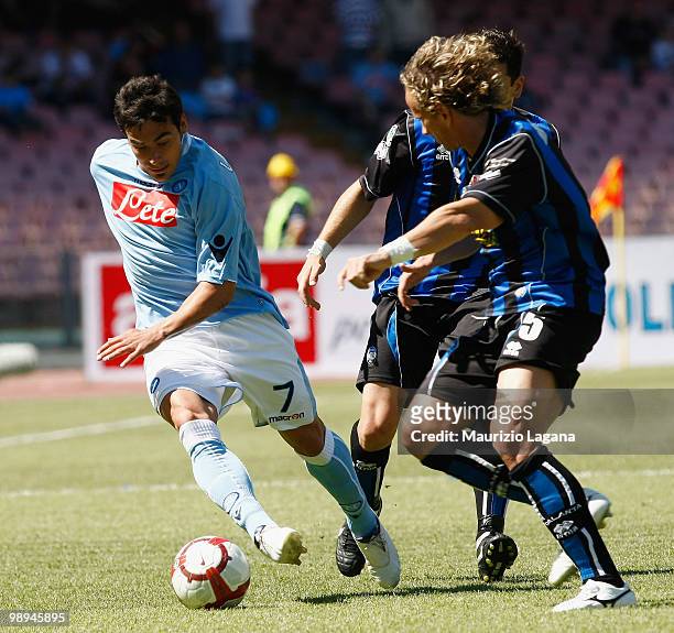 Ezequiel Lavezzi of SSC Napoli battles for the ball with Thomas Mafredini of Atalanta BC during the Serie A match between SSC Napoli and Atalanta BC...