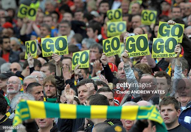 Supporters hold posters opposing Manchester United's US owner Malcolm Glazer before the English Premier League football match between Manchester...