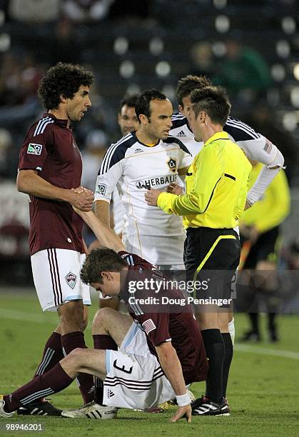 Referee Edvin Jurisevic talks to Landon Donovan of the Los Angeles Galaxy as Mehdi Ballouchy of the Colorado Rapids helps teammate Drew Moor up from...
