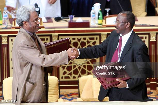 Representative of the Sudanese government Amin Hassan Omar and Sudanese rebel Justice and Equality Movement representative Ahmed Tugod Lsan exchange...