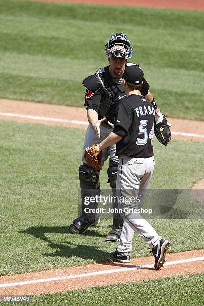 John Buck of the Toronto Blue Jays congratulates Jason Frasor of the Toronto Blue Jays during the game between the Toronto Blue Jays and the...