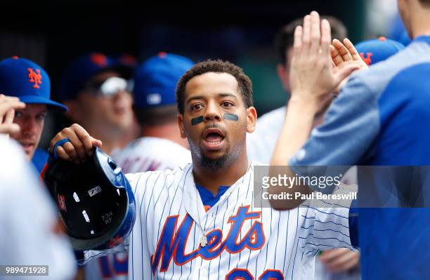 Dominic Smith of the New York Mets celebrates with teammates in the dugout after scoring a run in the second inning in an MLB baseball game against...