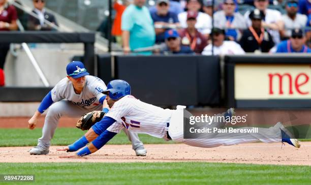 Jose Bautista of the New York Mets slides around Enrique Hernandez of the Los Angeles Dodgers to reach third base safely on a single by Dominic Smith...