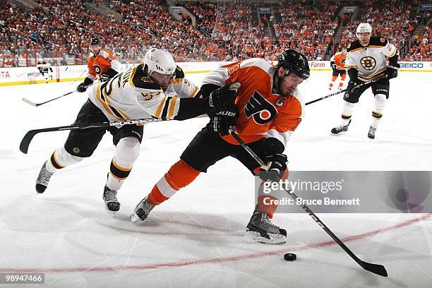 Johnny Boychuk of the Boston Bruins checks Mike Richards of the Philadelphia Flyers in Game Four of the Eastern Conference Semifinals during the 2010...