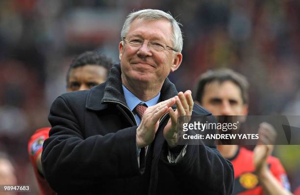 Manchester United manager Sir Alex Ferguson applauds the supporters on the pitch after the English Premier League football match between Manchester...