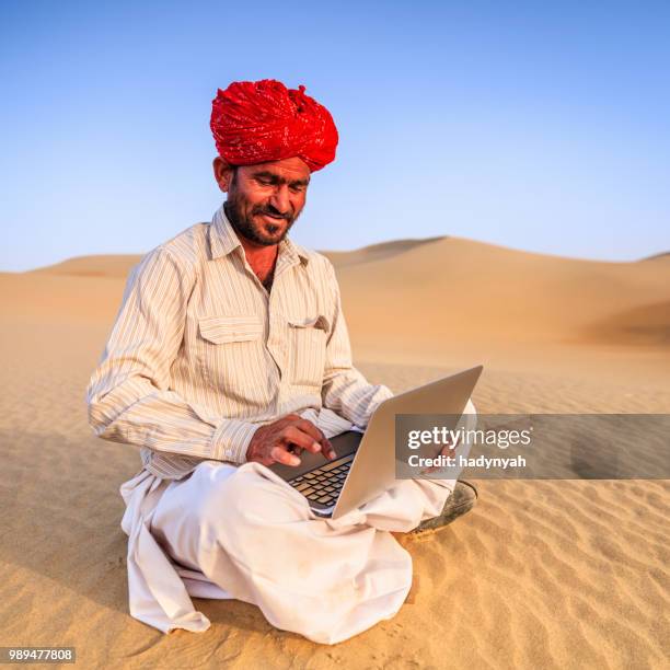 indian man using a laptop, desert village, india - laptop desert stock pictures, royalty-free photos & images