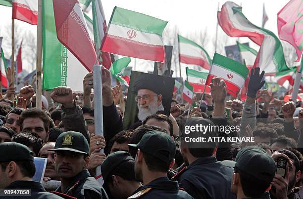 Iranian security froces stand guard as tens of thousands of Iranians, waving national flags and portraits of Supreme leader Ayatollah Ali Khamenei,...