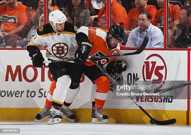 Mike Richards of the Philadelphia Flyers is checked by Steve Begin of the Boston Bruins in Game Four of the Eastern Conference Semifinals during the...
