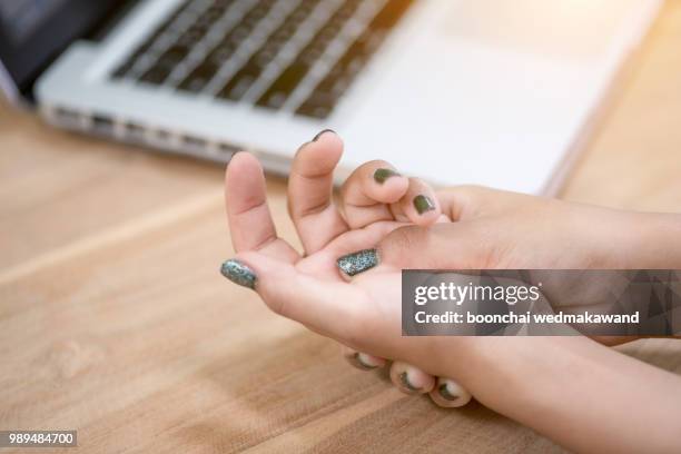 woman painful finger due to prolonged use of keyboard and mouse. - diagnosed stock pictures, royalty-free photos & images