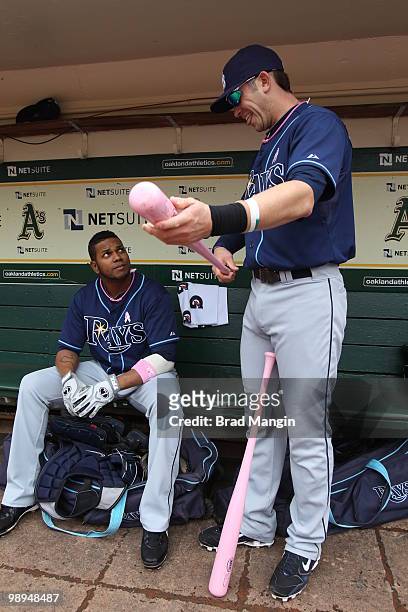 Willy Aybar and Evan Longoria of the Tampa Bay Rays get ready in the dugout before the game between the Tampa Bay Rays and the Oakland Athletics on...