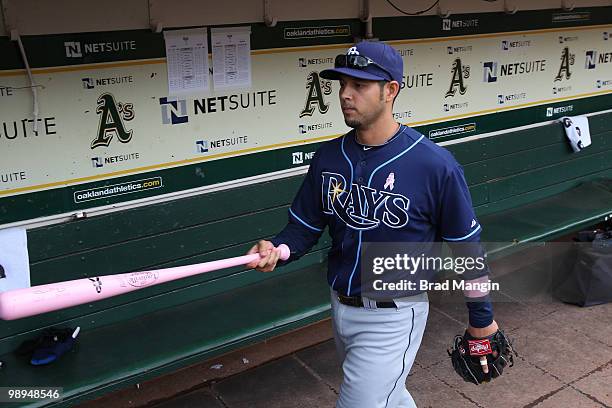 Jason Bartlett of the Tampa Bay Rays puts a pink bat in the bat rack in the Tampa Bay Rays dugout before the game between the Tampa Bay Rays and the...