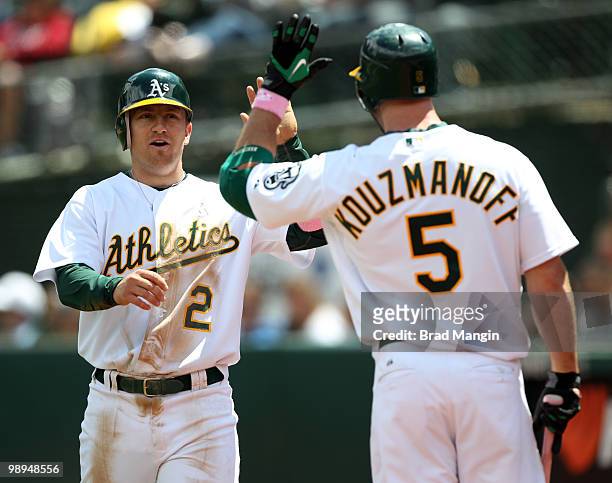 Cliff Pennington of the Oakland Athletics celebrates with Kevin Kouzmanoff after scoring a run during the game between the Tampa Bay Rays and the...