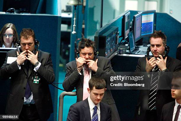 Traders speak on the telephone while on the floor of the London Metal Exchange in London, U.K., on Monday, May 10, 2010. The euro rallied and stocks...