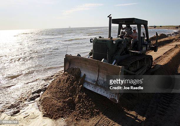Louisiana National Guard use a bulldozer to create a earthen barrier as they try to protect an estuary from the massive oil spill on May 10, 2010 in...