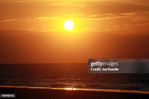 The sun rises over the Gulf of Mexico as efforts continue to try to protect the coast line from the massive oil spill on May 10, 2010 in Lafourche...