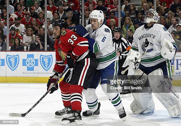 Dustin Byfuglien of the Chicago Blackhawks and Sami Salo of the Vancouver Canucks wait in position in front of Canucks goalie Roberto Luongo at Game...