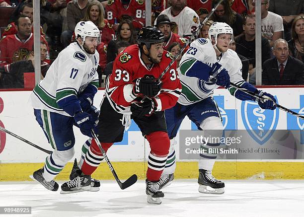 Dustin Byfuglien of the Chicago Blackhawks, Ryan Kesler and Alexander Edler of the Vancouver Canucks watch for the puck at Game Two of the Western...