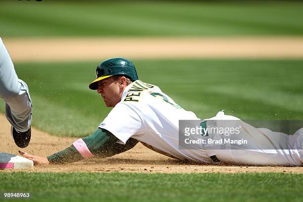 Cliff Pennington of the Oakland Athletics slides into third base during the game between the Tampa Bay Rays and the Oakland Athletics on Sunday, May...