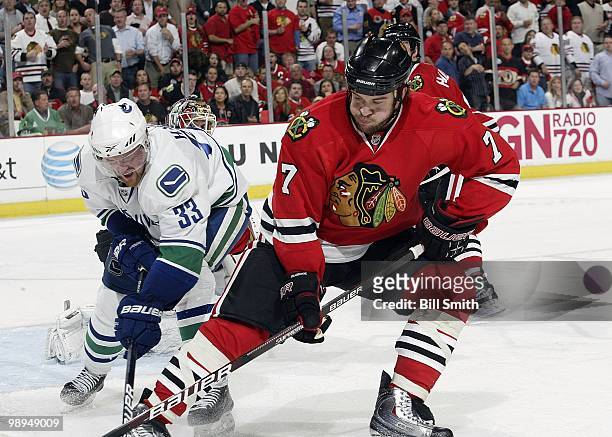 Brent Seabrook of the Chicago Blackhawks and Henrik Sedin of the Vancouver Canucks fight for the puck at Game Two of the Western Conference...