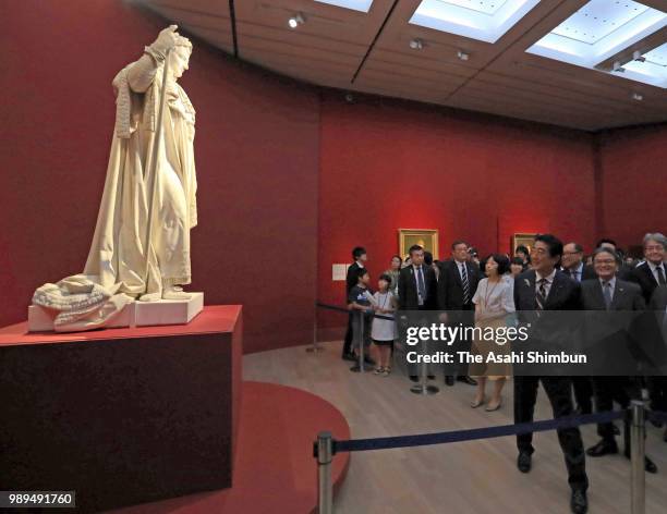 Japanese Prime Minister Shinzo Abe watches the 'Napoleon I in His Coronation Robes' during the 'Art of Portraiture in the Louvre Collections' at the...