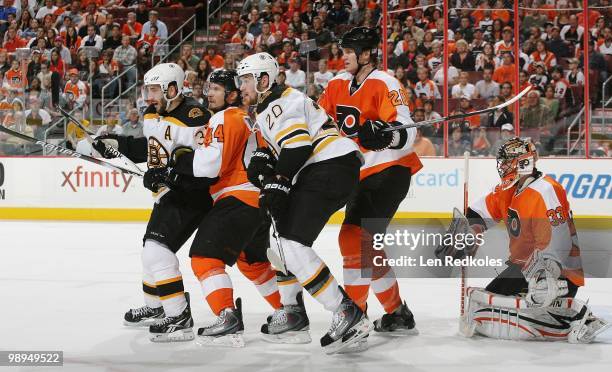 Kimmo Timonen, Chris Pronger and Brian Boucher of the Philadelphia Flyers battle in the crease against Patrice Bergeron and Daniel Paille of the...