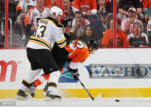 Claude Giroux of the Philadelphia Flyers is back checked off the puck by Zdeno Chara of the Boston Bruins in Game Four of the Eastern Conference...