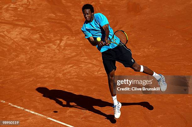 Gael Monfils of France leaps to play a backhand against Stephane Robert of France in their first round match during the Mutua Madrilena Madrid Open...