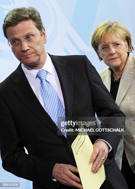 German Chancellor Angela Merkel and vice-chancellor and Foreign Minister Guido Westerwelle leave after a joint press conference on May 10, 2010 at...