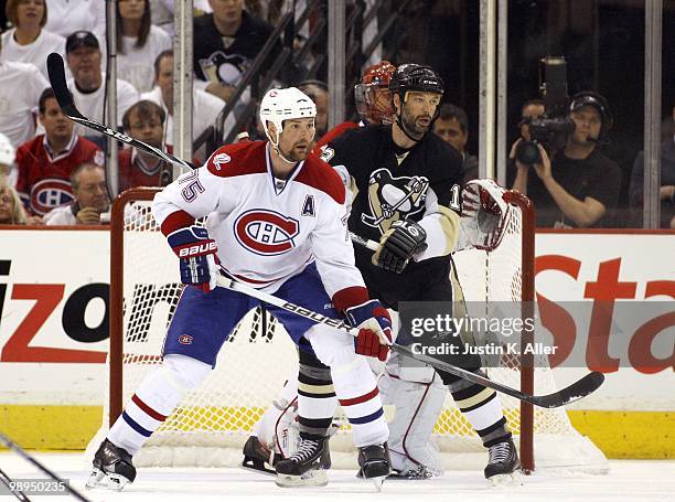 Hal Gill of the Montreal Canadiens and Bill Guerin of the Pittsburgh Penguins eye the puck in Game Five of the Eastern Conference Semifinals during...