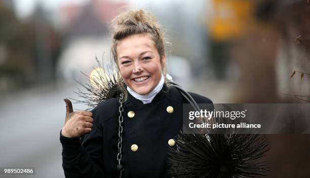 Chimney sweeper Romy Schneider carries her working equipment as she walks down a street in Riedlingen-Grueningen, Germany, 21 December 2017. 20-year...