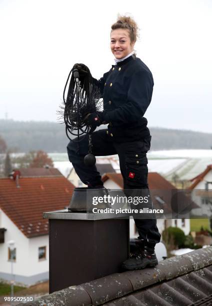 Chimney sweeper Romy Schneider stands next to a chimney on the rooftop of a residential building in Riedlingen-Grueningen, Germany, 21 December 2017....