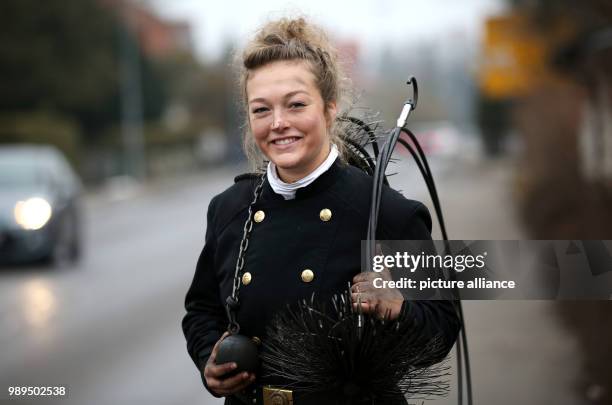 Chimney sweeper Romy Schneider carries her working equipment as she walks down a street, in Riedlingen-Grueningen, Germany, 21 December 2017. 20-year...
